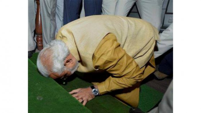 Prime Minister-elect Narendra Modi bends down on the steps of the main entrance of Parliament as a sign of respect as he arrives for the BJP parliamentary party meeting at Central Hall in New Delhi on Tuesday. PTI Photo Prime Minister-elect Narendra Modi bends down on the steps of the main entrance of Parliament as a sign of respect as he arrives for the BJP parliamentary party meeting at Central Hall in New Delhi on Tuesday. PTI Photo